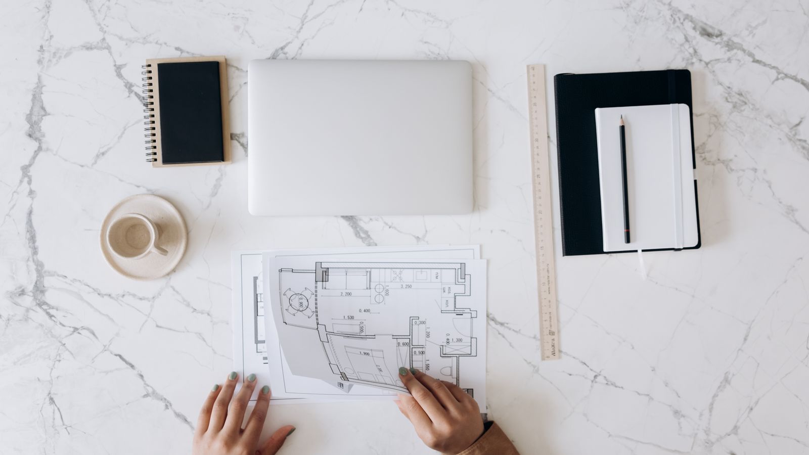 Construction plans and a laptop on a work desk