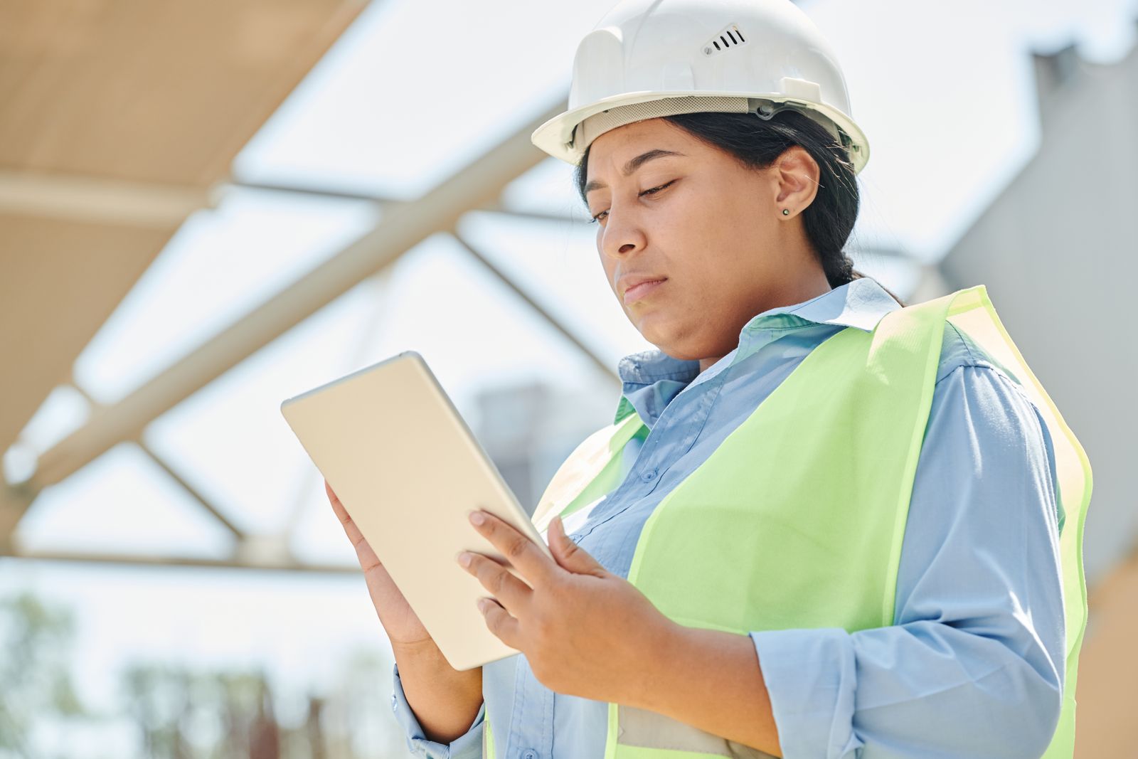 A construction project manager using a tablet on a jobsite